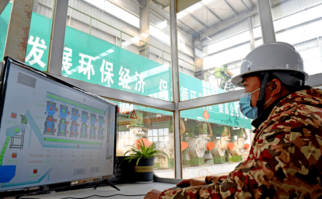 淮南市寿县一家颗粒厂工人正在操控秸秆颗粒机械设备加工秸秆，生产生物燃料